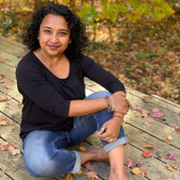Photo of Nadya Edwards, artist sitting on a deck in the fall.